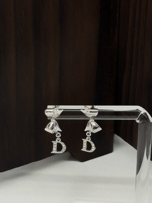 Dior silver rhinestone bow earrings with “D” charm